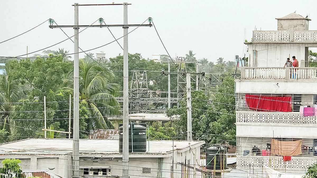 ৩৩ কেভি বৈদ্যুতিক খুঁটির নিচে ভবন নির্মাণ করে বসবাস করছে কয়েকটি পরিবার। সম্প্রতি বরিশাল নগরের পলাশপুর এলাকায়। ছবি: প্রথম আলো