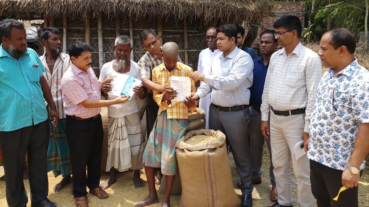 কৃষক হায়দার আলীর থেকে ধান কিনছেন ইউএনও এস এম গোলাম কিবরিয়া। নীলফামারী, সৈয়দপুর, ২৭ মে। ছবি: প্রথম আলো