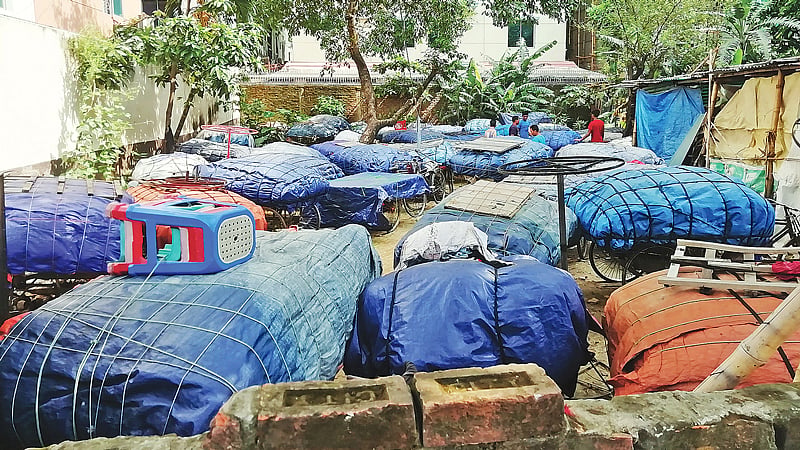 উত্তরায় চক্রাকার বাস সার্ভিসের উদ্বোধনী অনুষ্ঠানে মেয়রের আগমন উপলক্ষে রাস্তা–ফুটপাত দখল করে রাখা ভ্যানগাড়িগুলো একটি খালি প্লটে সরিয়ে রাখা হয়। গতকাল দুপুরে।  প্রথম আলো