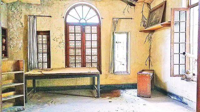 বাংলা একাডেমির বর্ধমান হাউসের দ্বিতীয় তলায় ‘নজরুল স্মৃতিকক্ষ’ বর্তমান অবস্থা। দেয়ালে গাছের শিকড়, জীর্ণ আসবাব। নষ্ট হচ্ছে চিত্রকর্ম। ছবি গত রোববার তোলা।  প্রথম আলো