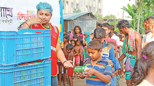 শিশুদের হাতে এক টাকায় ইফতারি দিচ্ছেন স্বেচ্ছাসেবীরা।