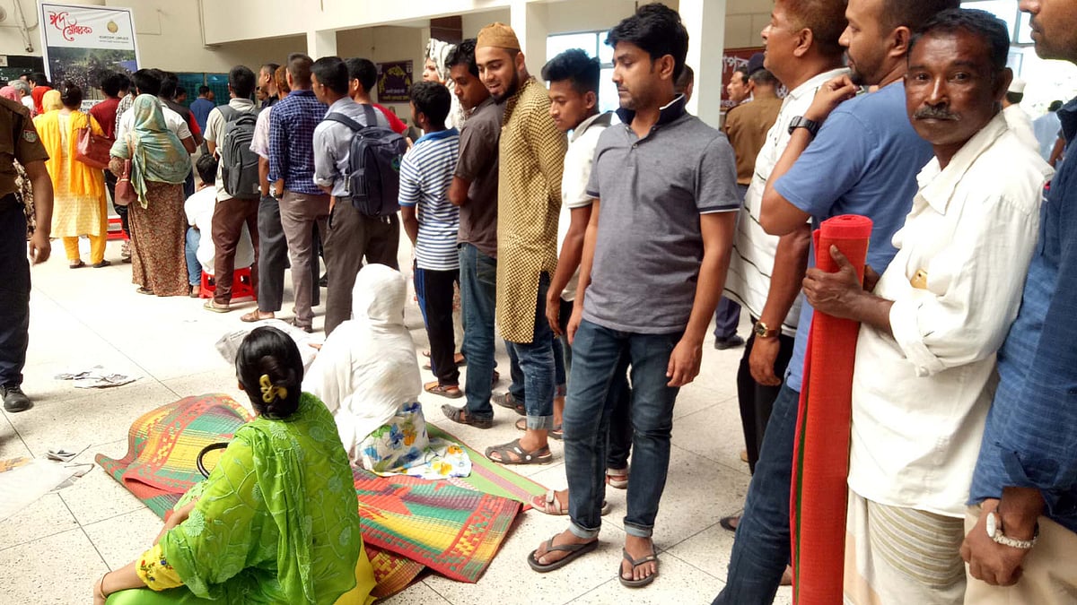 রাজশাহীতে ট্রেনের ফিরতি টিকিটের জন্য এভাবেই রাত–দিন সারিতে দাঁড়িয়ে থাকতে হচ্ছে টিকিটপ্রত্যাশীদের। আজ শুক্রবার সকাল ১০টায় রাজশাহী রেলওয়ে স্টেশনে। ছবি: প্রথম আলো