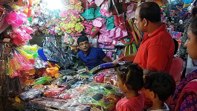 মেলায় শিশুদের নিয়ে খেলনার দোকানে এক অভিভাবক। ঢাকা, ০৭ জুন। ছবি: মাসুম আলী