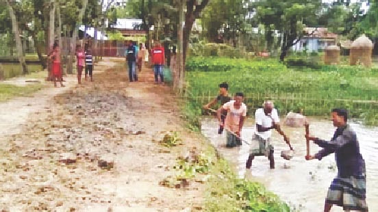 কাঁচা সড়কের সংস্কারকাজে মাটির পরিবর্তে ফেলা হচ্ছে কাদা। গত সোমবার মৌলভীবাজারের কুলাউড়া উপজেলার কর্মধা গ্রামের মনাই মহাজনের বাড়ির সামনে।  প্রথম আলো