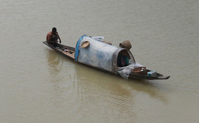 সিলেটের সুরমা নদীতে নৌকায় করে মাছ ধরছেন এক মৎস্যজীবী। মাছিমপুর, সিলেট, ২০ জুন। ছবি: আনিস মাহমুদ