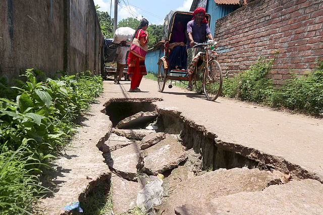 দীর্ঘদিন ধরে সড়কটি ভেঙে পড়ে থাকলেও তা সংস্কারের কোনো উদ্যোগ নেই। ফলে মাঝে মাঝে দুর্ঘটনার শিকার হচ্ছেন পথচারীরা। লম্বাপাড়া, রাধানগর, পাবনা, ২৩ জুন। ছবি: হাসান মাহমুদ