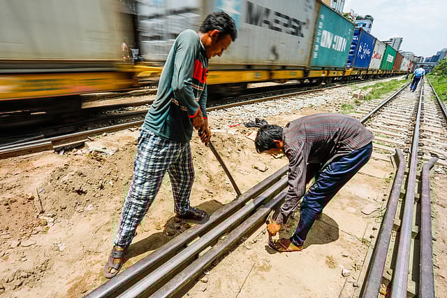 রেললাইনের সংস্কারকাজ করছেন পিডব্লিউডির দুই কর্মচারী। মগবাজার রেলক্রসিং, ঢাকা, ২৪ জুন। ছবি: দীপু মালাকার