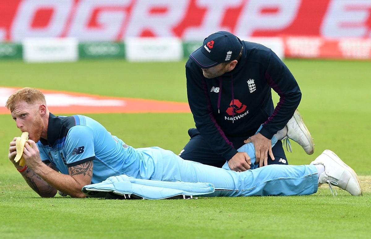 পায়ে হঠাৎ টান লেগেছিল, তাই একটু শুশ্রূষা চলছিল বেন স্টোকসের। সেই বিরতিতেই কলা খেয়ে শক্তি বাড়িয়ে নিচ্ছিলেন স্টোকস। ছবি: এএফপি