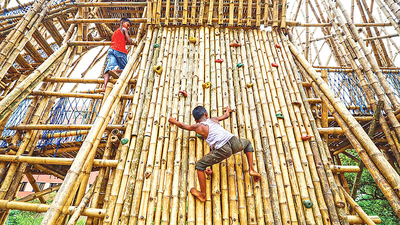 বাঁশের দেয়াল বেয়ে ওপরে উঠছে এক দুরন্ত কিশোর। বাঁশের তৈরি খেলার নানা রকম স্থাপনা তৈরি করেছেন বুয়েট ও ব্র্যাক বিশ্ববিদ্যালয়ের স্থাপত্য বিভাগের শিক্ষার্থীরা। সব বয়সের শিশু-কিশোরের জন্য উন্মুক্ত এই খেলাঘর।  ছবি: দীপু মালাকার