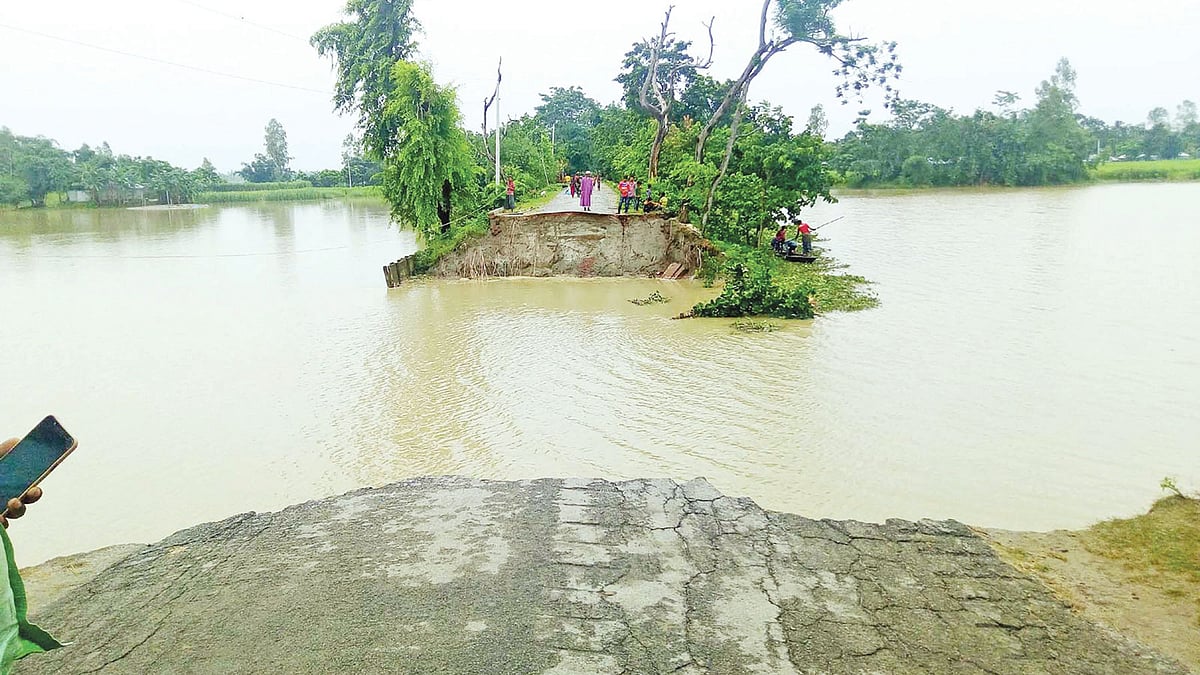 কয়েক দিনের বৃষ্টিপাত ও উজান থেকে আসা পাহাড়ি ঢলে সড়ক ভেঙে ধরলা নদীতে বিলীন হয়েছে। এতে তিনটি গ্রামের প্রায় তিন হাজার মানুষ দুর্ভোগে পড়েছেন। গতকাল লালমনিরহাট সদর উপজেলার দক্ষিণ শিবের কুঠি গ্রামে। ছবি: প্রথম আলো