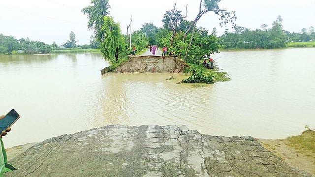কয়েক দিনের বৃষ্টিপাত ও উজান থেকে আসা পাহাড়ি ঢলে সড়ক ভেঙে ধরলা নদীতে বিলীন হয়েছে। এতে তিনটি গ্রামের প্রায় তিন হাজার মানুষ দুর্ভোগে পড়েছেন। গতকাল লালমনিরহাট সদর উপজেলার দক্ষিণ শিবের কুঠি গ্রামে।  ছবি: প্রথম আলো