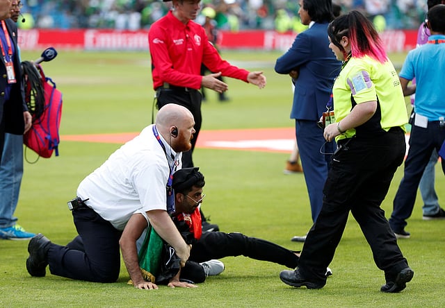 ইংল্যান্ডের মাঠে দর্শক ঢুকে পড়ার ঘটনা এক সময় খুব স্বাভাবিক ছিল। দলে দলে লোক ঢুকে খেলোয়াড়দের জড়িয়ে ধরার দৃশ্যও স্বাভাবিক ছিল। আজ আফগানিস্তান ও পাকিস্তান ম্যাচ শেষে অনেক দিন পর এমন কিছু হলো। দুই দলের দর্শক মাঠে নেমে মারামারিও করল! এমনই একজনকে ধরে মাঠ থেকে বের করে নিয়ে যাচ্ছেন নিরাপত্তা কর্মী। ছবি: রয়টার্স