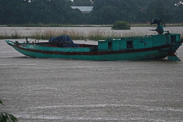 ঝুম বৃষ্টিতে চলছে মালবাহী নৌকা।