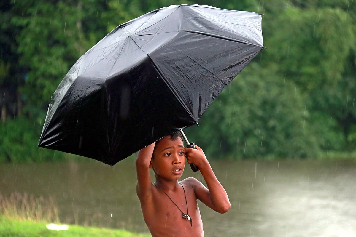 বৃষ্টিতে ছাতা মাথায় শিশু।