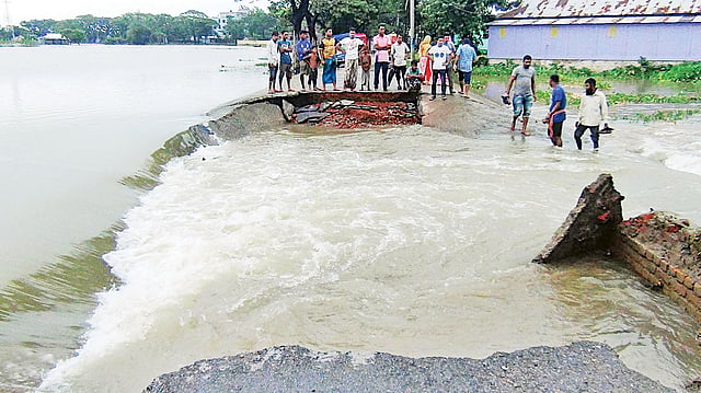 পাহাড়ি ঢল আর অতিবৃষ্টিতে বেড়েছে পানি। সড়ক ভেঙে সুরমা নদীর পানি ঢুকছে লোকালয়ে। গতকাল বিকেলে সুনামগঞ্জ পৌর শহরের নবীনগর এলাকায়।  ছবি: প্রথম আলো