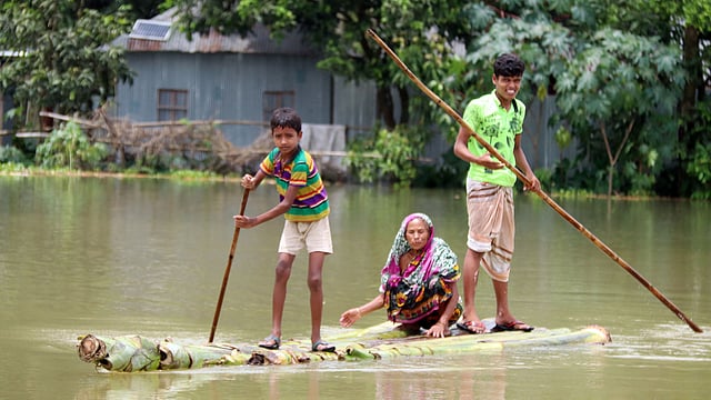 কলাগাছের ভেলায় বয়স্ক এক নারীকে নিরাপদে সরিয়ে নেওয়া হচ্ছে।