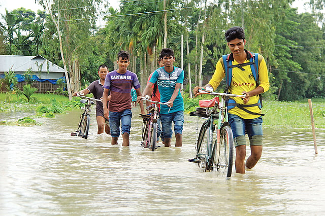হাঁটুপানি ঠেলে পার হচ্ছে কলেজপড়ুয়ারা। গতকাল কাউনিয়ার কালীহাট এলাকায়।