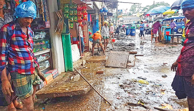 চলছে নর্দমা পরিস্কারের কাজ। রোববার মৌলভীবাজারের রাজনগর উপজেলা সদরের কাঁচাবাজার এলাকায়।  ছবি: প্রথম আলো