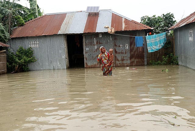 কোলের শিশুকে নিয়ে বাড়ির উঠানে এক মা। আউচারপাড়া, সারিয়াকান্দি, বগুড়া