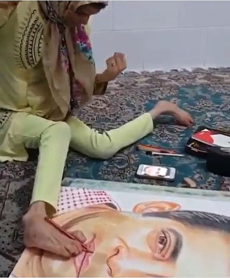 একজন প্রতিবন্ধী নারী পায়ের সাহায্যে রং–তুলি দিয়ে সালমান খানকে এঁকেছেন