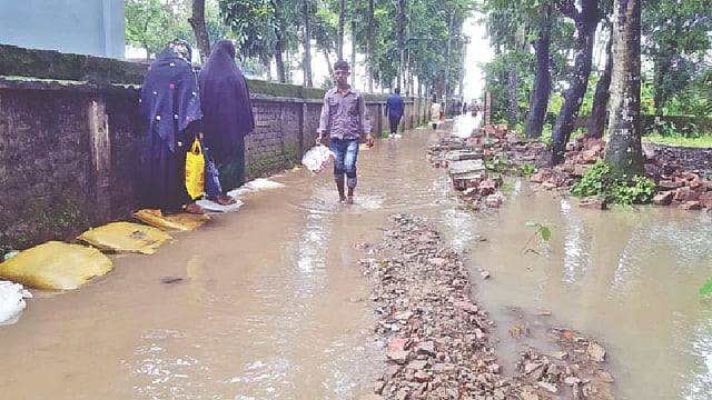 ভাঙাচোরা সড়ক। তার ওপর পানিতে তলিয়ে আছে। পথচারীদের দুর্ভোগের শেষ নেই। গত বৃহস্পতিবার সড়কের আনসার ক্যাম্প এলাকায়।   প্রথম আলো