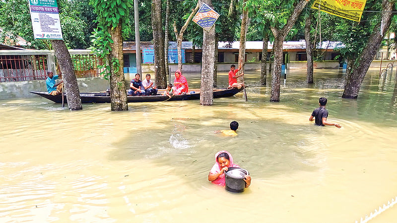 বন্যার পানিতে জামালপুরে ঘরবাড়ি, শিক্ষাপ্রতিষ্ঠান সব তলিয়ে গেছে। নৌকা নিয়ে চলাচল করছে মানুষ। গতকাল সকালে দেওয়ানগঞ্জ উপজেলা পরিষদ প্রাঙ্গণে। ছবি: প্রথম আলো
