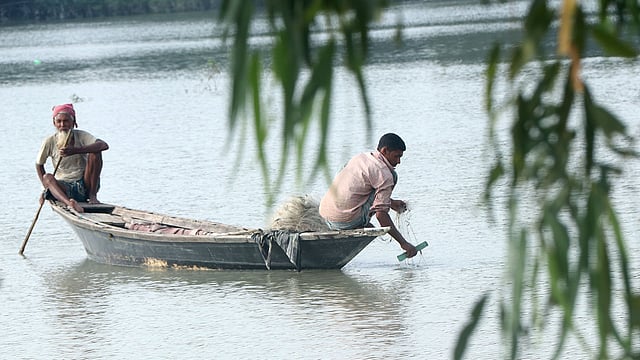 জাল দিয়ে মাছ শিকার করছেন দুই শিকারি
