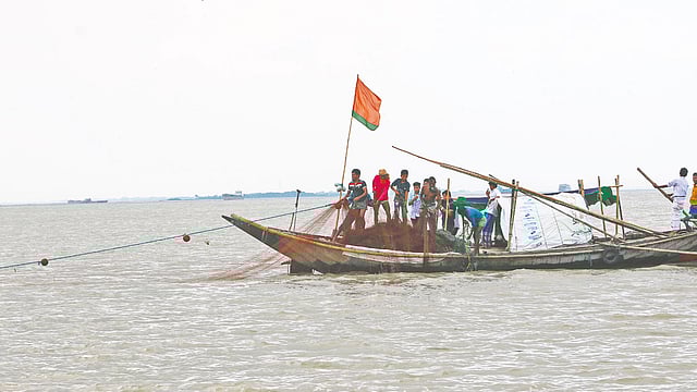নৌকায় চলছে জাল গোটানোর কাজ