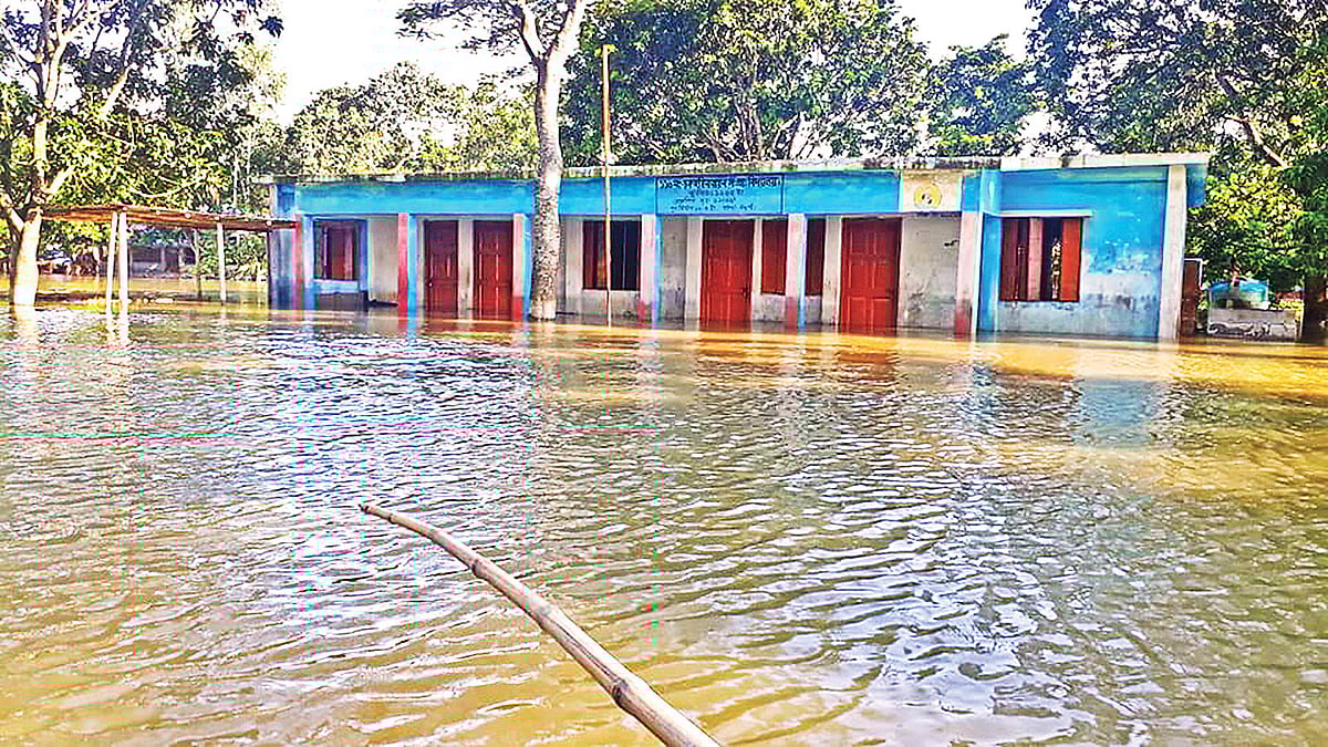 পানি ওঠায় নওগাঁর মান্দা উপজেলার চকহরি নারায়ণপুর সরকারি প্রাথমিক বিদ্যালয়ে পাঠদান বন্ধ রয়েছে।  ছবি: প্রথম আলো