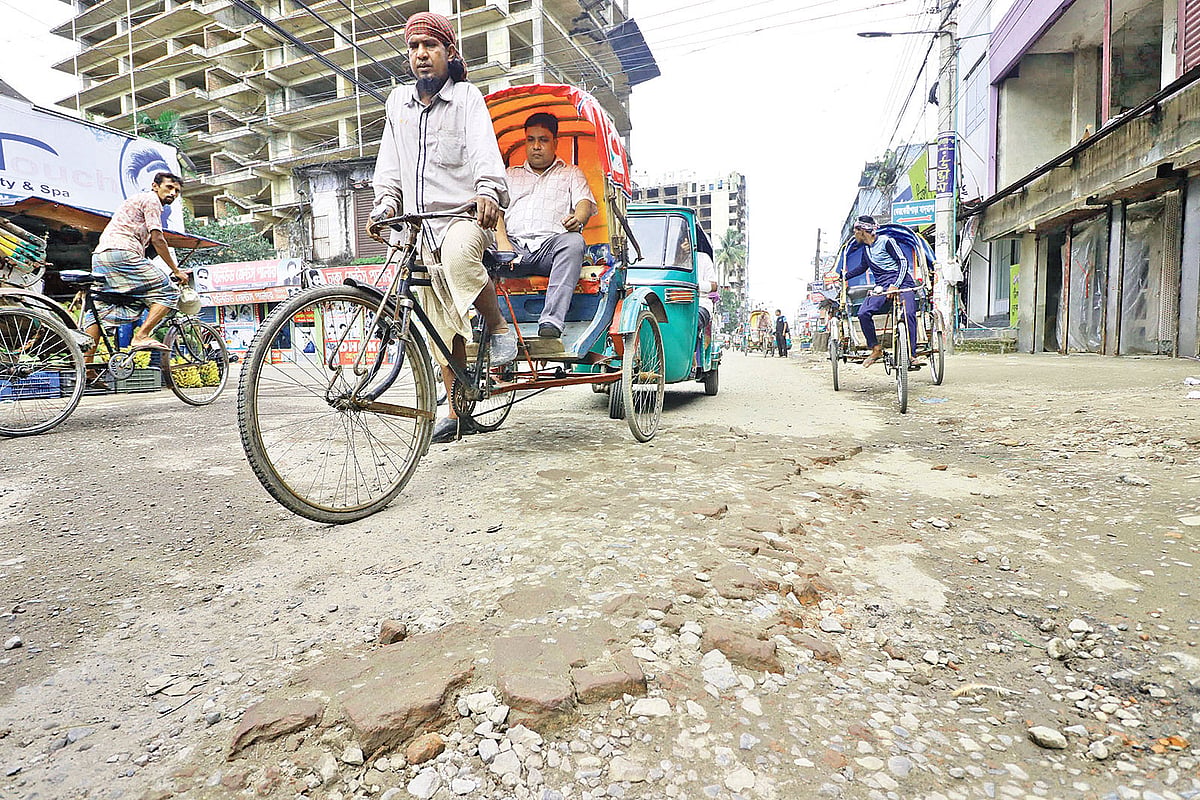 ভাঙাচোরা আর গর্ভে ভরা সড়কে ভোগান্তি নিয়ে চলাচল করছে বিভিন্ন যানবাহন। গতকাল বিকেলে নাইওরপুল-টিলাগড় সড়কের মিরাবাজার এলাকায়। ছবি: প্রথম আলো