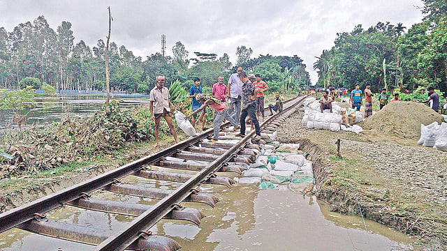 বন্যার পানির স্রোতে গাইবান্ধা সদর উপজেলায় রেলপথ ক্ষতিগ্রস্ত হয়েছে। গতকাল তা সংস্কারের কাজ শুরু হয়েছে। দুপুরে বাদিয়াখালী স্টেশন এলাকায়।  ছবি: প্রথম আলো
