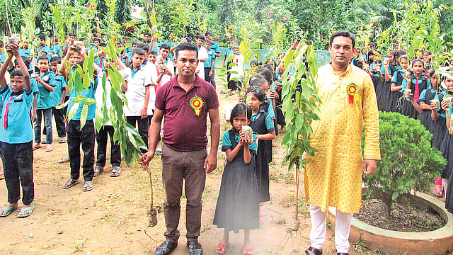 টিফিনের টাকা বাঁচিয়ে কেনা গাছের চারা বিতরণ করছেন লাল-সবুজ উন্নয়ন সংঘের সদস্যরা। গতকাল মৌলভীবাজারের কুলাউড়া উপজেলার চুনঘর সরকারি প্রাথমিক বিদ্যালয়ে। প্রথম আলো