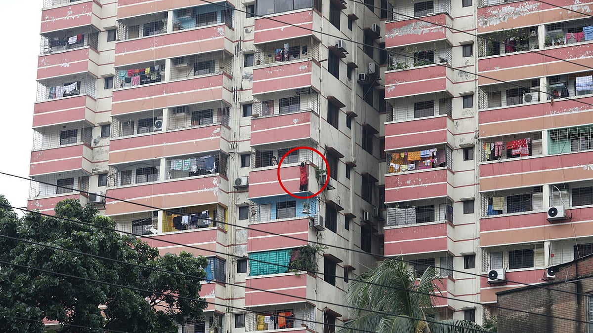 ১৫ তলা ভবনের দশম তলার বারান্দার বাইরে গ্রিল ধরে ঝুলে আছে খাদিজা। সার্কিট হাউস সড়ক, রমনা, ঢাকা, ৩০ জুলাই। ছবি: আবদুস সালাম