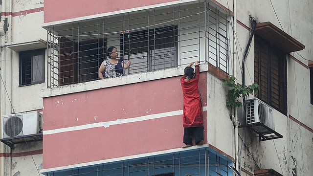 ১৫ তলা ভবনের দশম তলার বারান্দার বাইরে গ্রিল ধরে ঝুলে আছে খাদিজা। গ্রিলের দরজাটি তখন ছিল তালাবদ্ধ। সার্কিট হাউস সড়ক, রমনা, ঢাকা, ৩০ জুলাই। ছবি: আবদুস সালাম