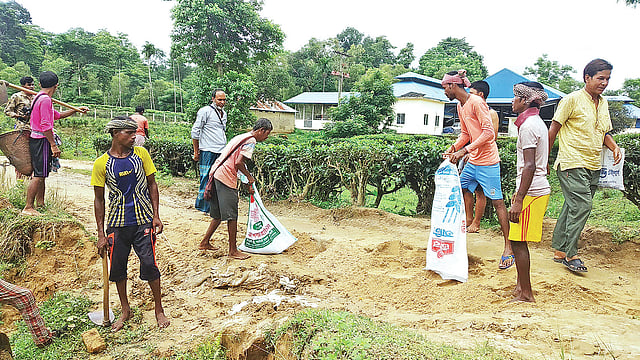 স্বেচ্ছাশ্রমে সড়ক সংস্কারের কাজ করছেন খাসিয়াপুঞ্জিতে বসবাসকারী মানুষেরা। গতকাল সকালে মৌলভীবাজারের শ্রীমঙ্গলের লাংলিয়া খাসিয়াপুঞ্জির প্রবেশপথে।  ছবি: প্রথম আলো