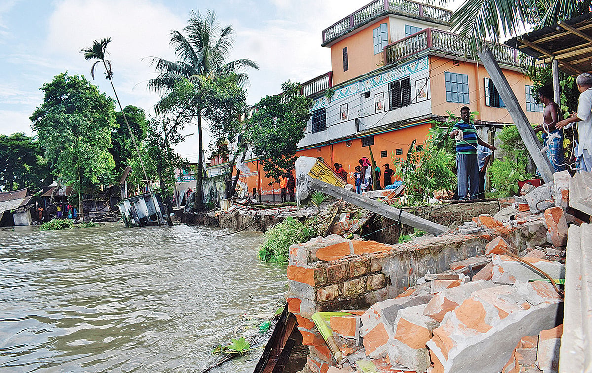 চাঁদপুর শহরের পুরান বাজারে হরিসভা এলাকায় শহর রক্ষা বাঁধের কিছু অংশে ভাঙন তীব্র আকার ধারণ করেছে। গতকাল বেলা ১১টায়।  ছবি: প্রথম আলো