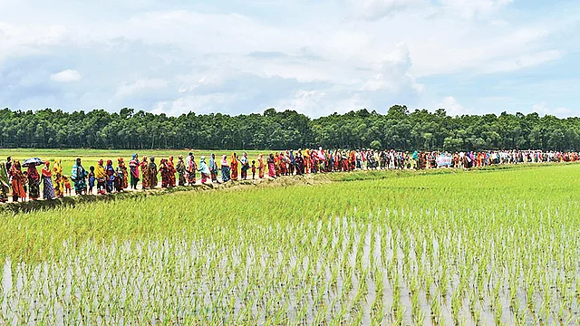 নবাবগঞ্জে আশুরার বিলে আড়াআড়ি বাঁধ নির্মাণ বন্ধের দাবিতে ১৮টি গ্রামের মানুষ মানববন্ধন করে। গত রোববার বিলের ভেতর।  ছবি: প্রথম আলো