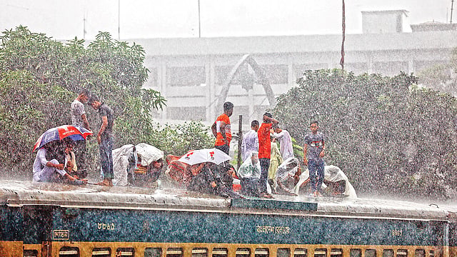 ঈদের আগে শেষ কর্মদিবস ছিল কাল। ঈদযাত্রায় মানুষের ভিড় ছিল তাই বেশি। বৃষ্টি উপেক্ষা করে ট্রেনের ছাদে চড়ে বাড়ি ফিরছেন অনেকে। গতকাল দুপুরে রাজধানীর বিমানবন্দর স্টেশনে।  ছবি: তানভীর আহাম্মেদ