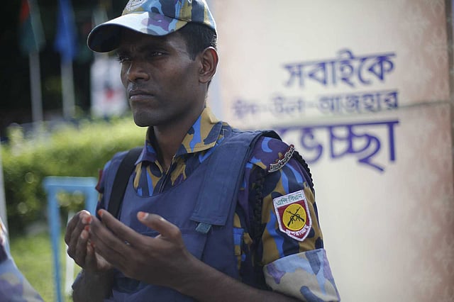 মোনাজাত করছেন নিরাপত্তার দায়িত্বে থাকা আইনশৃঙ্খলারক্ষাকারী বাহিনীর এক সদস্য। ছবি: হাসান রাজা