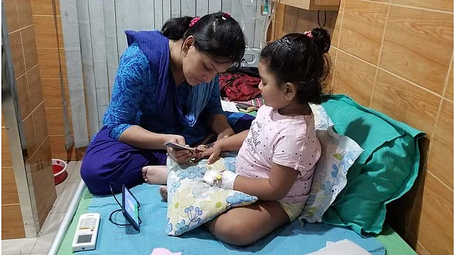 হাসপাতালের বিছানায় মেয়ের হাতে মেহেদি লাগিয়ে দিচ্ছেন এক মা। ছবি: ফেসবুক