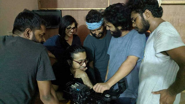 ‘শিকলবাহা’র ক্যাম্পে শুটিংয়ের ফাঁকে দল নিয়ে ক্যামেরায় প্রিভিউ করছেন কামার আহমাদ সাইমন, পেছনে সারা আফরীন