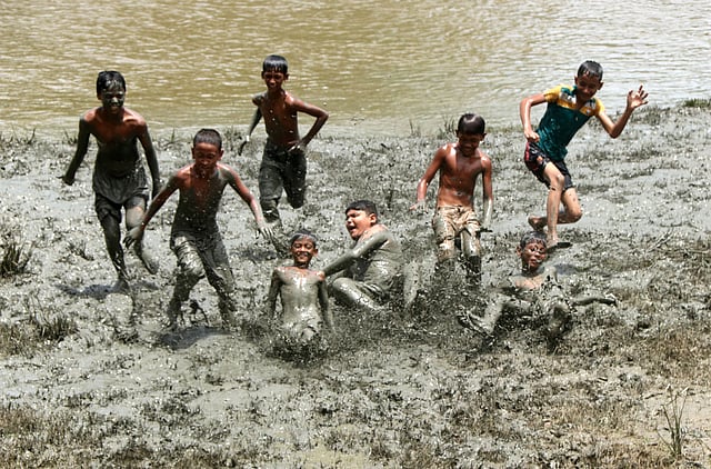 নদীর পাড়ের কাদায় শিশুদের দুরন্তপনা।
