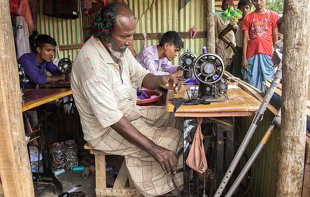 কৃত্রিম দুই পা দিয়েই  পা-চালিত সেলাই মেশিন চালান মাঝবয়সী মো. আলম। ছবি: সাবরিনা ইয়াসমীন