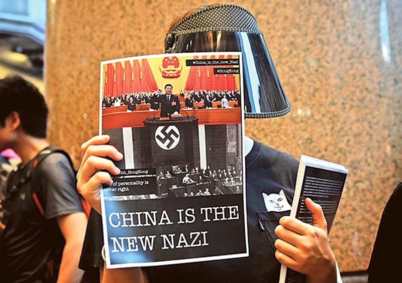 প্ল্যাকার্ড হাতে এক বিক্ষোভকারী। গতকাল হংকংয়ের কজওয়ে বে এমটিআর স্টেশনে। ছবি: এএফপি