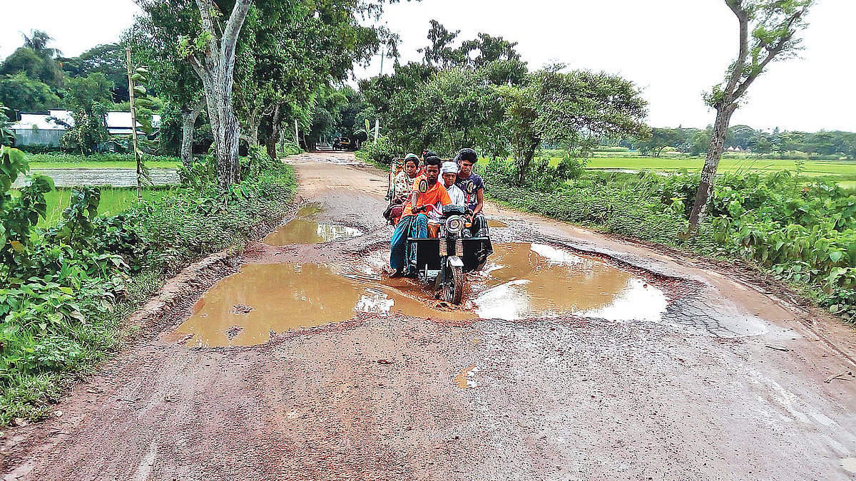 নান্দাইল-দেওয়ানগঞ্জ সড়কে কিছুদূর পরপর এ রকম খানাখন্দ। ঝুঁকি নিয়ে চলছে যানবাহন। গত রোববার শেরপুর এলাকায়। ছবি: প্রথম আলো