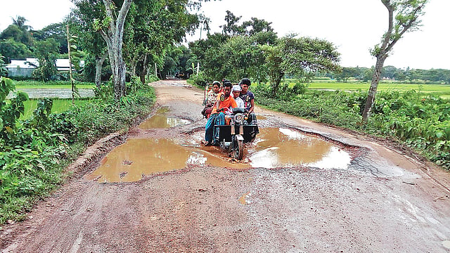 নান্দাইল-দেওয়ানগঞ্জ সড়কে কিছুদূর পরপর এ রকম খানাখন্দ। ঝুঁকি নিয়ে চলছে যানবাহন। গত রোববার শেরপুর এলাকায়।  ছবি: প্রথম আলো