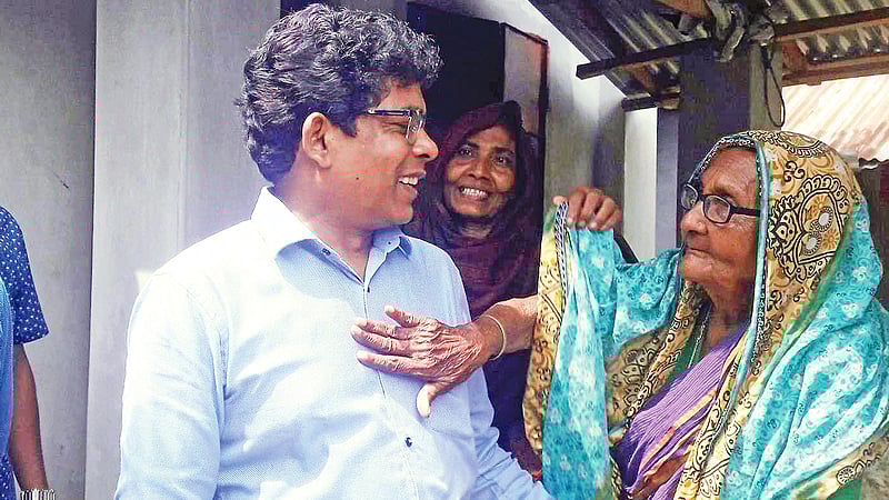 রাজশাহীর বাগমারার পূর্বপাড়া গ্রামের বৃদ্ধা ভানু বেওয়ার বাড়িতে জেলা প্রশাসক। গতকাল সকালে। প্রথম আলো