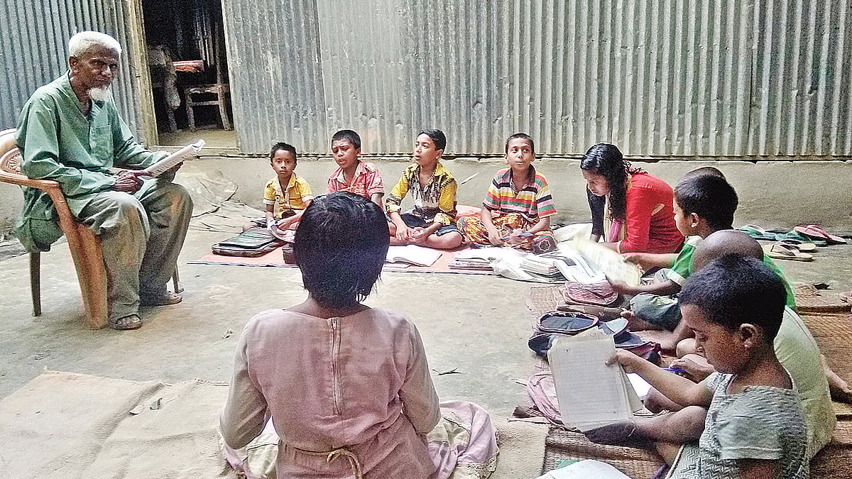 আঙিনায় পড়াচ্ছেন এক টাকার মাস্টার লুৎফর রহমান। সম্প্রতি বাগুড়িয়া গ্রামে। প্রথম আলো