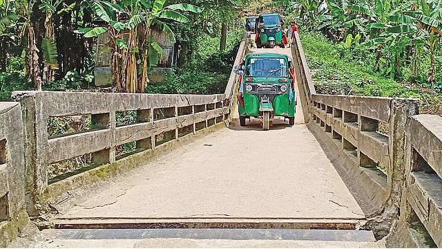 ভাঙা সেতুতে ঝুঁকি নিয়ে চলাচল করছে যানবাহন। গত শুক্রবার পানছড়ির দুদুকছড়ায়। প্রথম আলো