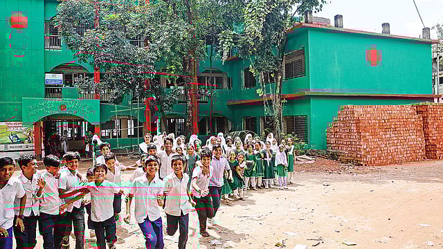 লাল-সবুজ রঙের বিশাল জাতীয় পতাকা আঁকা। প্রথম দেখায় মনে হবে বিদ্যালয়টি যেন এক বিশাল রঙিন ক্যানভাস। সম্প্রতি বছিলায়।  ছবি: আশরাফুল আলম